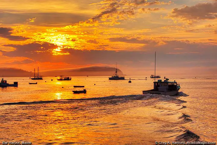 A lobster boat leaves the public pier in Bar Harbor at sunrise.