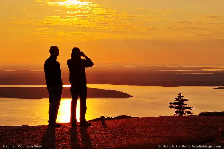 A couple looks at the distant islands and ships at sea
