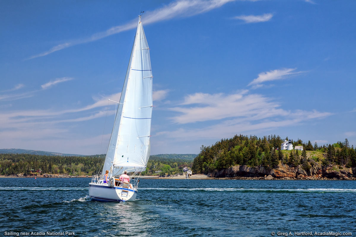 A sailboat passes by Bear Island Lighthouse in Acadia National Park