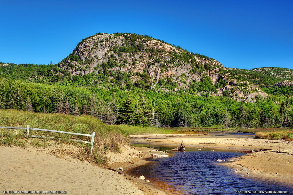 The Beehive with a sand dune fence at Sand Beach in Acadia National Park
