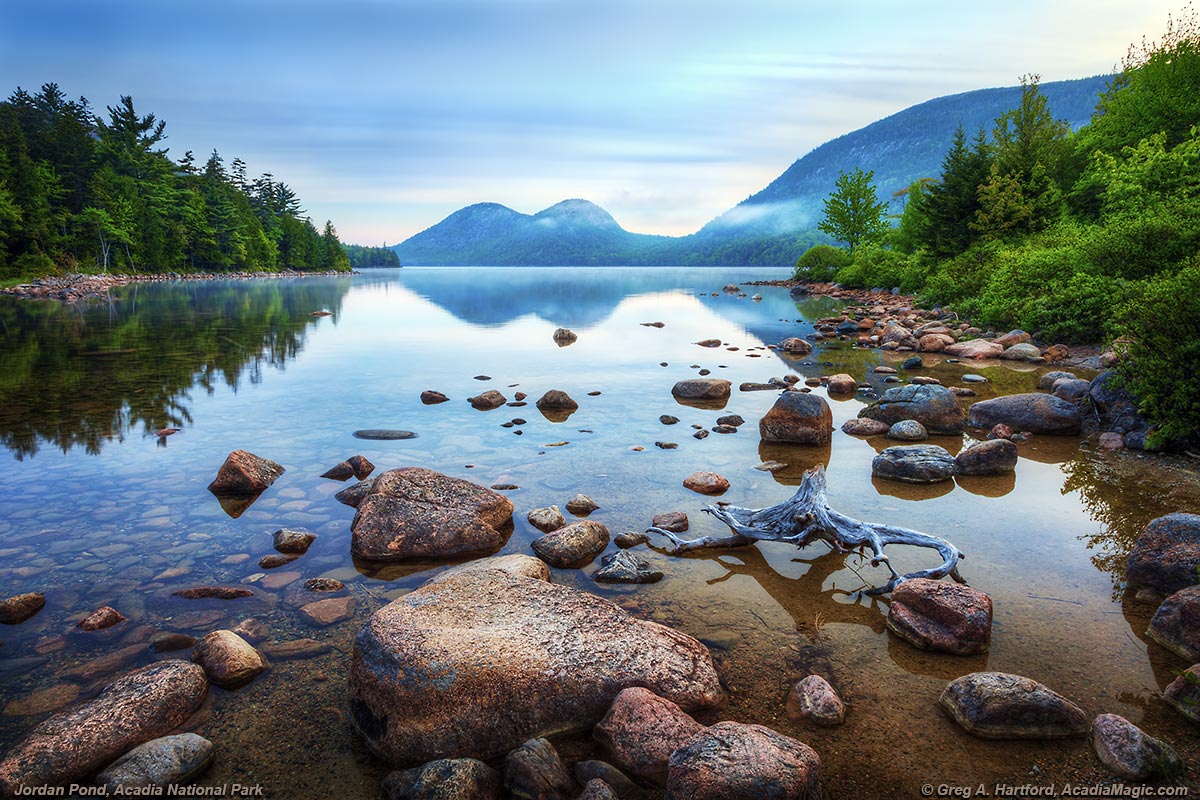 A calm Jordan Pond with reflection of The Bubbles