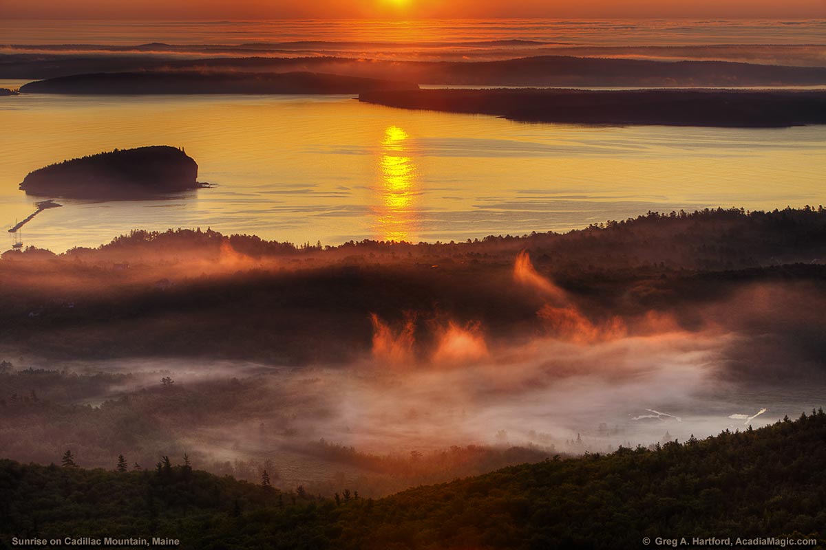 Surise lights up Bar Harbor fog seen from Cadillac Mountain in Acadia National Park