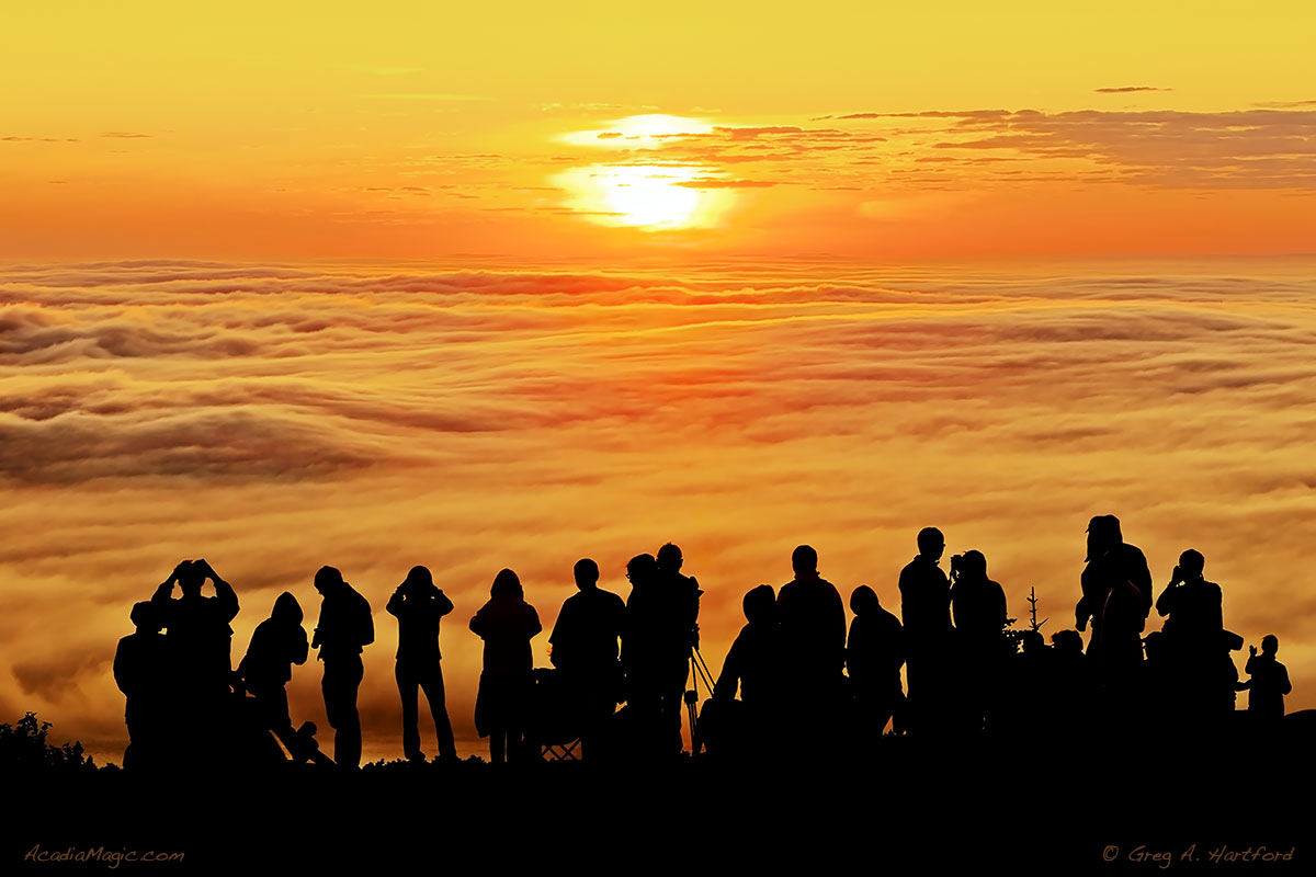 This image appears almost tribal as a large crowd stands in awe of the sunrise on Cadillac Mountain.