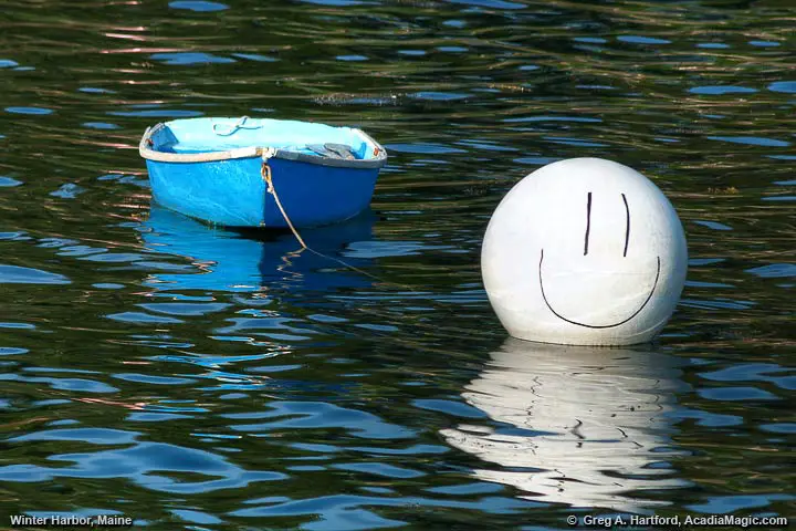 Smiley face on buoy next to dinghy